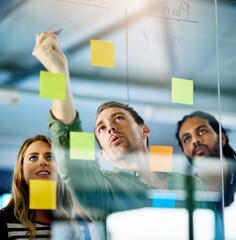 Wall Mural - Combining knowledge for the good of business. Shot of colleagues having a brainstorming session with sticky notes at work.