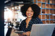 © N Hiraman/peopleimages.com - Shes always happy to be in the office. Portrait of a young focussed female designer working on her laptop and digital tablet at the office during the day.