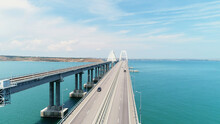 Top View Of Beautiful Bridge Over Blue Sea. Shot. Long Highway With Bridge Over Blue Water. Bridge Across Strait Between Islands With Beautiful Seascape On Sunny Day