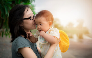 beautiful young mother and baby, happy family asia cute baby and mom outdoor, happy mother hug her b