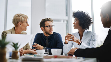 Poster - Give us difficult and well show you easy. Shot of a group of businesspeople sitting together in a meeting.