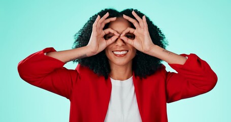 Canvas Print - Face, fun and finger glasses with a black woman comic in studio on a blue background for humor. Portrait, funny and joking with an attractive or playful young female making a hand gesture indoor