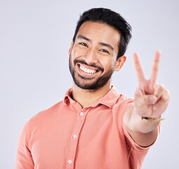 Wall Mural - portrait, smile and peace sign of asian man in studio isolated on a gray background. face, v hand em