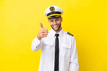 Wall Mural - Airplane caucasian pilot isolated on yellow background with thumbs up because something good has happened