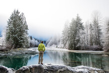 A Man Stands Next To The Taylor River On A Foggy Day In Winter.