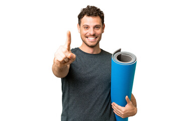 Wall Mural - Young sport man going to yoga classes while holding a mat over isolated chroma key background showing and lifting a finger