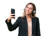 Telemarketer pretty Uruguayan woman working with a headset over isolated background making a selfie