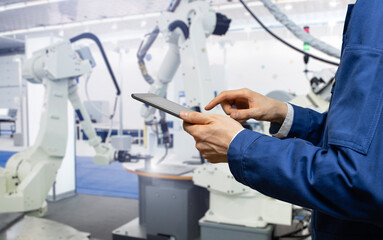 Aufkleber - Engineer uses a digital tablet to control robots in a smart factory. Smart industry 4.0 concept	
