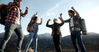 © andreybiling - Students on hike adventure - Four young authentic people cheering on top of mountain, doing a highfive, expressing positive emotions - friendship, travel destination