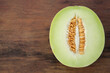 Half of tasty ripe melon on wooden table, top view. Space for text