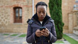 © Krakenimages.com - African american woman using smartphone with serious expression at park