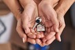 © Krakenimages.com - Woman and girl mother and daughter hands holding key at new home