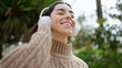 © Krakenimages.com - Young beautiful hispanic woman smiling confident listening to music at park