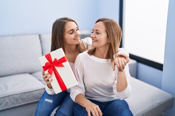 Canvas Print - Two women mother and daughter surprise with birthday gift at home