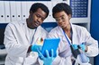 © Krakenimages.com - African american man and woman scientists using touchpad working at laboratory
