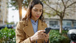 © Krakenimages.com - Young beautiful hispanic woman using smartphone with serious face at park