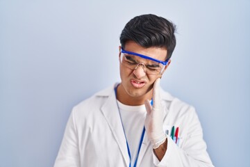 Sticker - Hispanic man working as scientist touching mouth with hand with painful expression because of toothache or dental illness on teeth. dentist