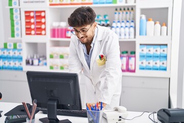 Poster - Young arab man pharmacist using computer working at pharmacy