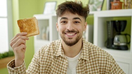 Sticker - Young arab man smiling confident holding toast at home