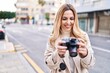 © Krakenimages.com - Young blonde woman smiling confident using professional camera at street