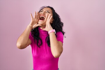 Poster - Young asian woman standing over pink background shouting angry out loud with hands over mouth