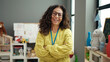 © Krakenimages.com - Middle age hispanic woman preschool teacher smiling confident standing with arms crossed gesture at kindergarten