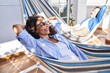 © Krakenimages.com - Middle age hispanic couple relaxed with hands on head lying on hammock at terrace