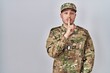 © Krakenimages.com - Young hispanic man wearing camouflage army uniform asking to be quiet with finger on lips. silence and secret concept.