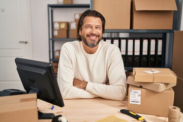 Canvas Print - Handsome middle age man working at small business ecommerce happy face smiling with crossed arms looking at the camera. positive person.