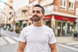 © Krakenimages.com - Young hispanic man smiling confident standing at street
