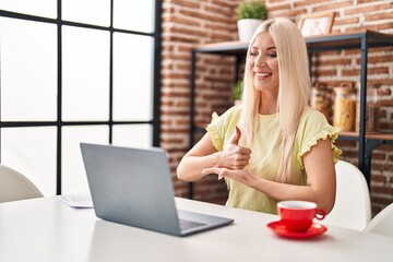 Wall Mural - Young blonde woman having video call using deaf language at home