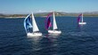 Sailing yachts in a regatta, in a race, go under colored sails (gennakers).  Aerial footage, drone view
