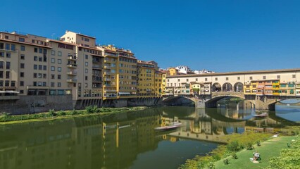 Canvas Print - The Ponte Vecchio on a sunny day timelapse hyperlapse, a medieval stone segmental arch bridge over the Arno River, in Florence, Italy. Noted for still having shops built along it, as was once common