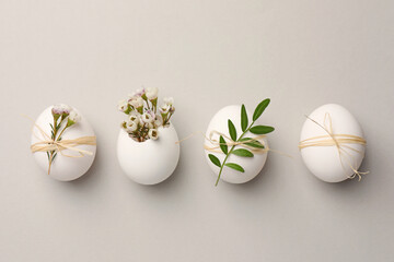 festive composition with chicken eggs and natural decor on light grey background, flat lay. happy ea