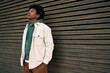 © insta_photos - Cool young hipster gen z African American teen standing at wooden wall. Sensitive vulnerable ethnic rebel teenage boy breathing air with eyes closed feeling free or sad in city outdoors.