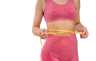 Wall Mural - Fitness woman with athletic figure measuring her waist with centimeter tape measure.Fit woman in pink sportswear isolated on white background showing her figure.In a pink outfit
