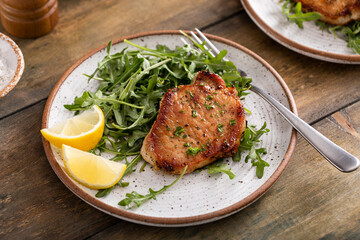 Wall Mural - Pork chops served with arugula salad on a plate