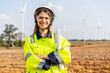 © TeTe Song - Portrait of caucasian engineer woman in uniform working in the wind turbine area, wearing white hard hat, crosses his arms over his chest, and looks at camera confidently away from the white windmill