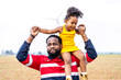 © TeTe Song - Black african father engineer holds his daughter in his arms at the wind turbines with great freedom. Concept of environmental engineering, renewable energy and love for nature and for the family