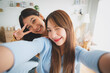 © Monster Ztudio - Two asian young women happy smiling and taking selfie in living room at home. Video call, Meeting conference