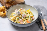 Fototapeta Kuchnia - Italian made fettuccine pasta with creamy sauce and grilled salmon.
