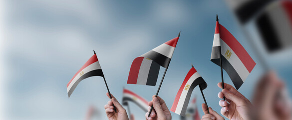 Wall Mural - A group of people holding small flags of the Egypt in their hands