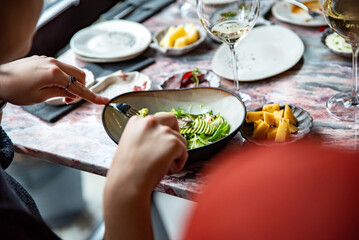 woman hand eating salad in restaurant