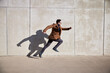 © baranq - Casual man running in urban setting wearing coat on sunny spring day
