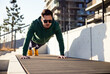 © baranq - Handsome man doing push-ups outside in the city