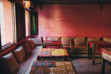 Wall Mural - Oriental hospitality. Traveling by Morocco. Relaxing in festive moroccan traditional riad interior in medina. Comfortable terrace filled with soft, cozy furniture.