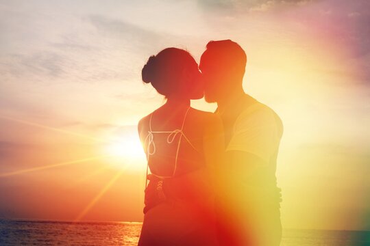 silhouette sunset : senior business man and his wife hugging and kissing on celebration event at the