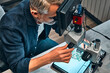 © HBS - Development of microchips, technology.Engineer looks at a microcircuit through a microscope.