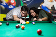 © Vesna - A guy and a young and beautiful woman are playing billiards in a club