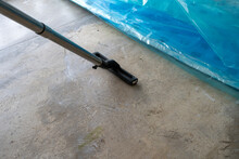 Prepping the Concrete Floor: Vacuuming Sand and Dust Before Applying Plastic Covering,